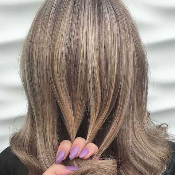 Back of the head of a woman with blond, wavy hair and highlights, created with Wella Professionals.